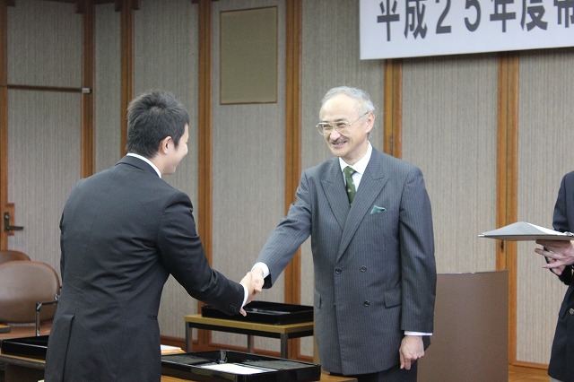 握手を交わす卒業生と飛世学部長